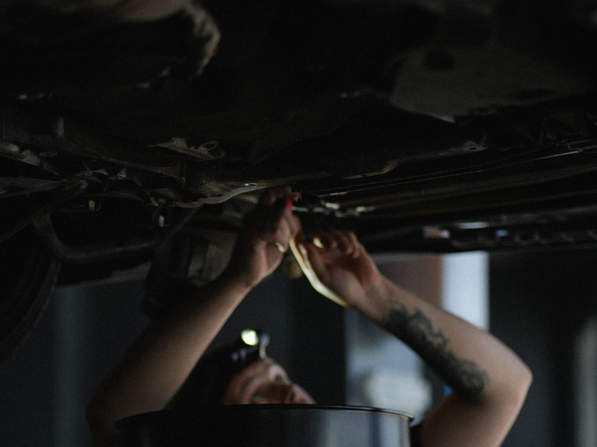 Mechanic working under a car at Pulsecar