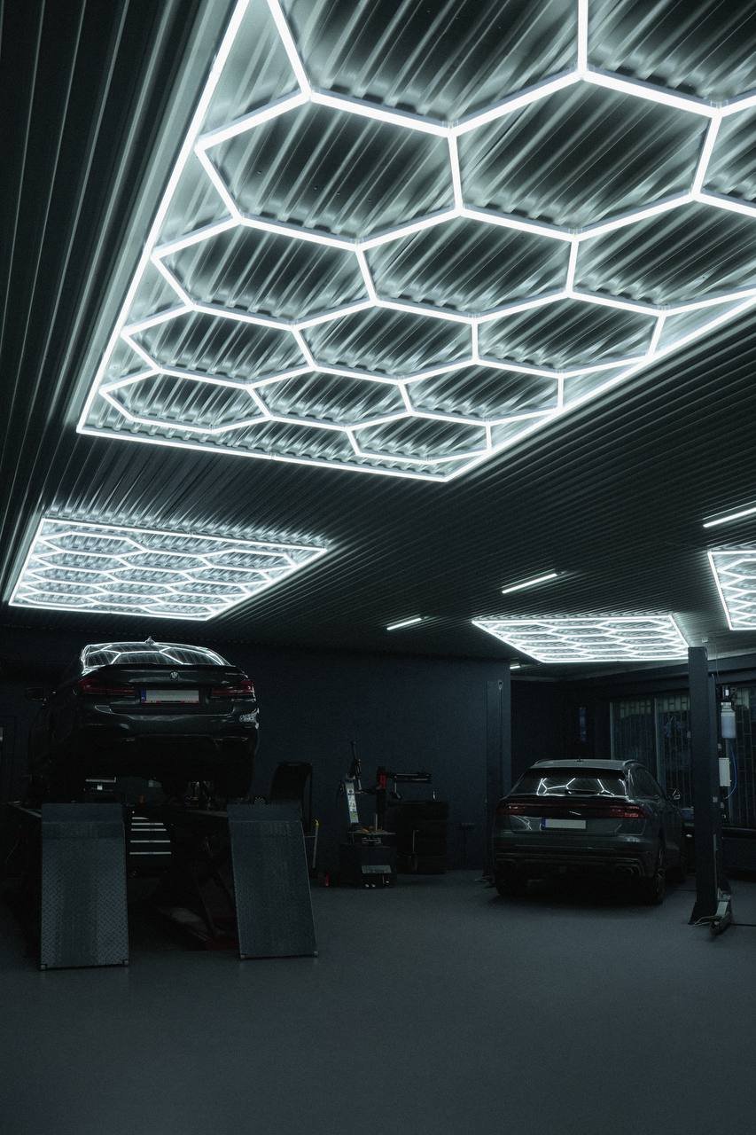 Wnętrze warsztatu PulseCar z samochodami i oświetleniem hex LED