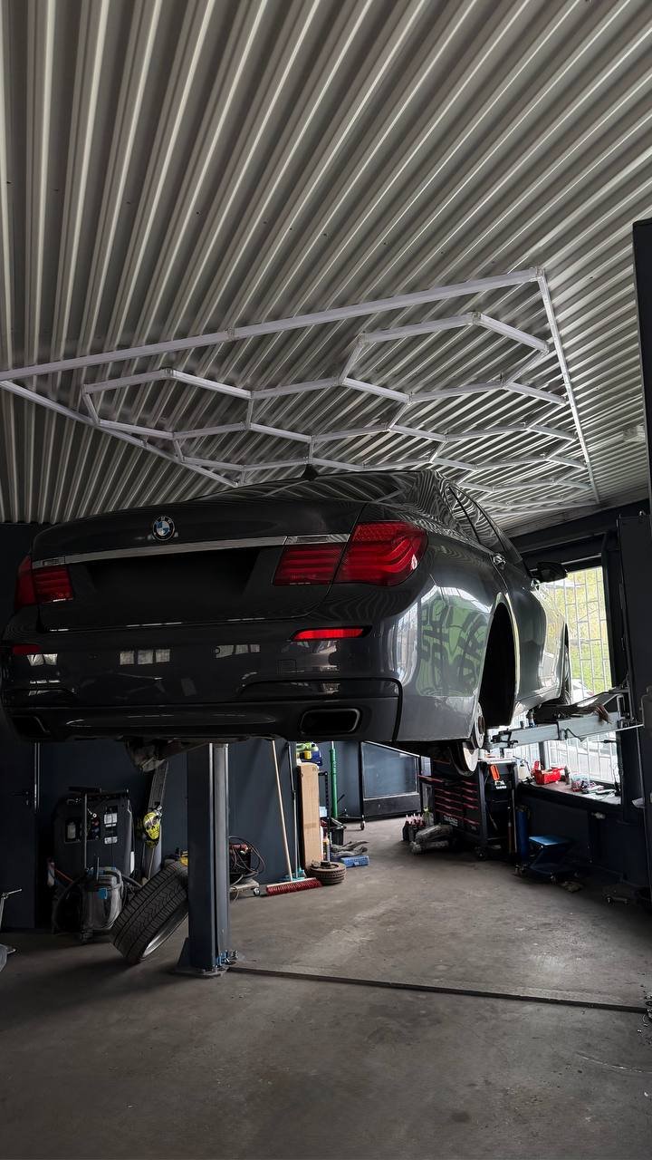 Black car on lift in garage with metal roof