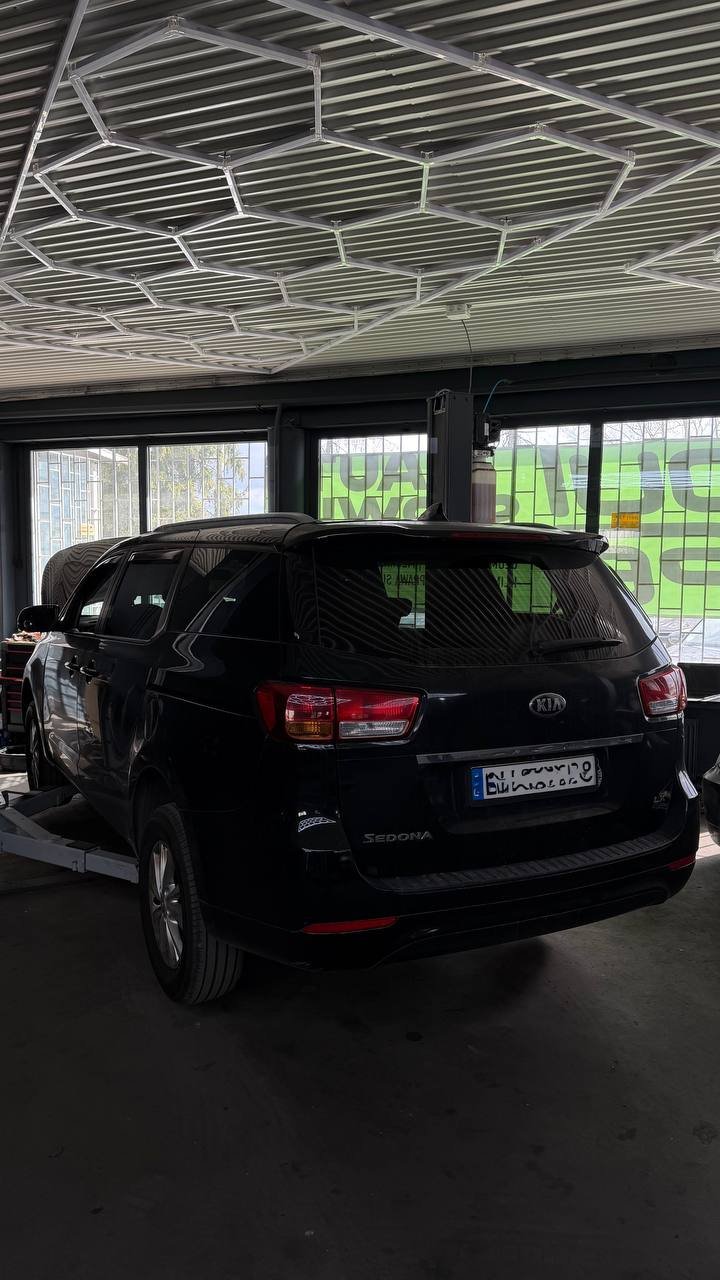 Black Kia Sedona in garage with metal roof